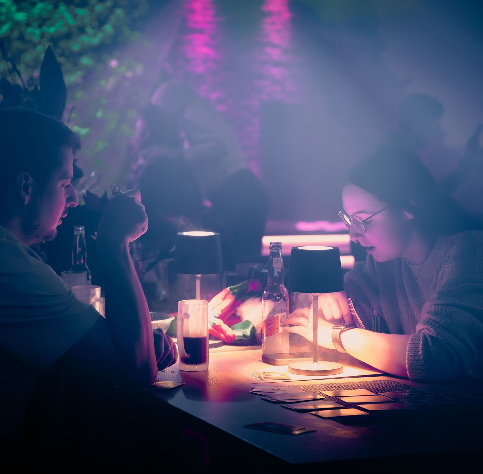 Gäste an einer gedeckten Tafel mit Tischlampen