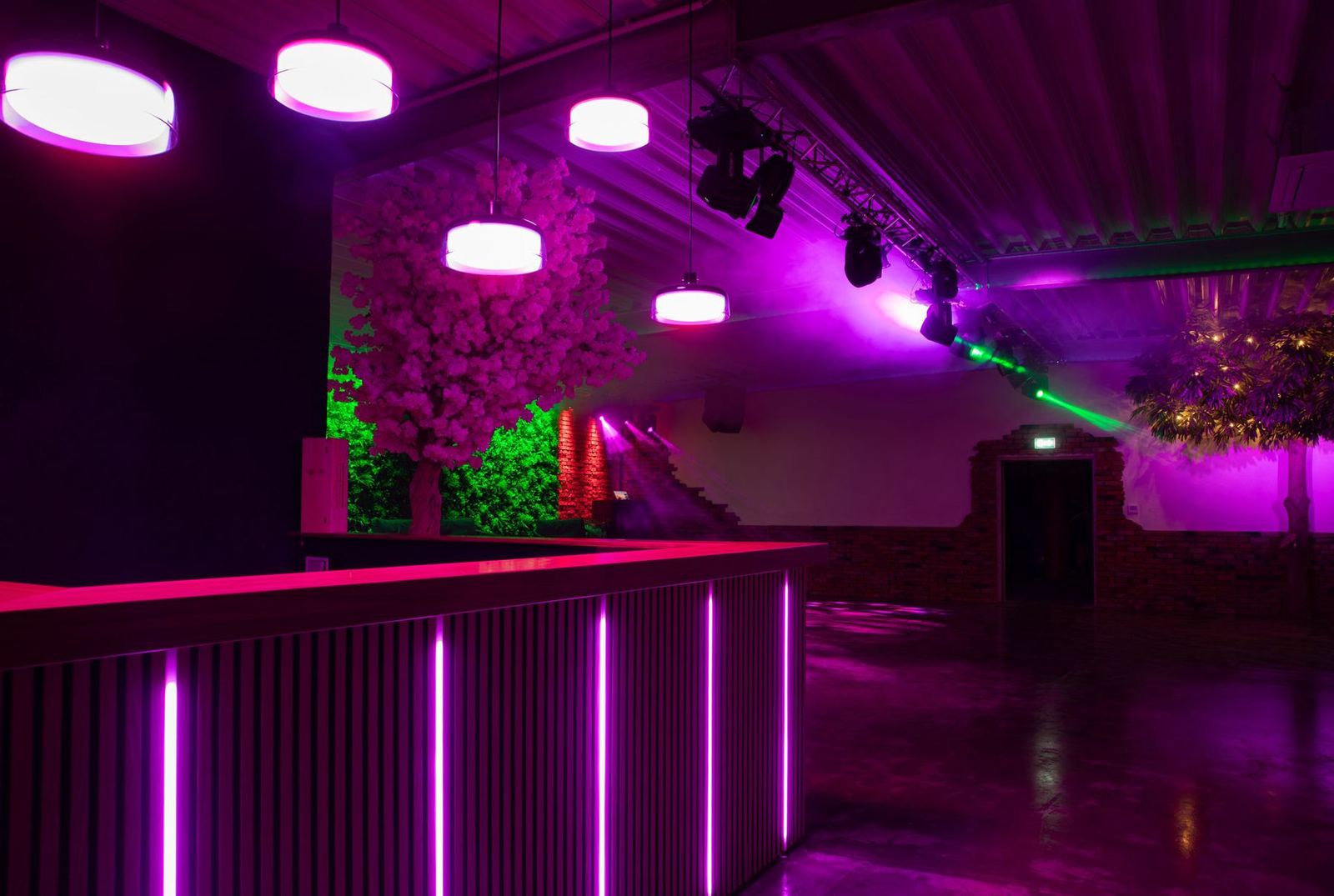 Eventlocation mit magentafarben beleuchteter Bar
