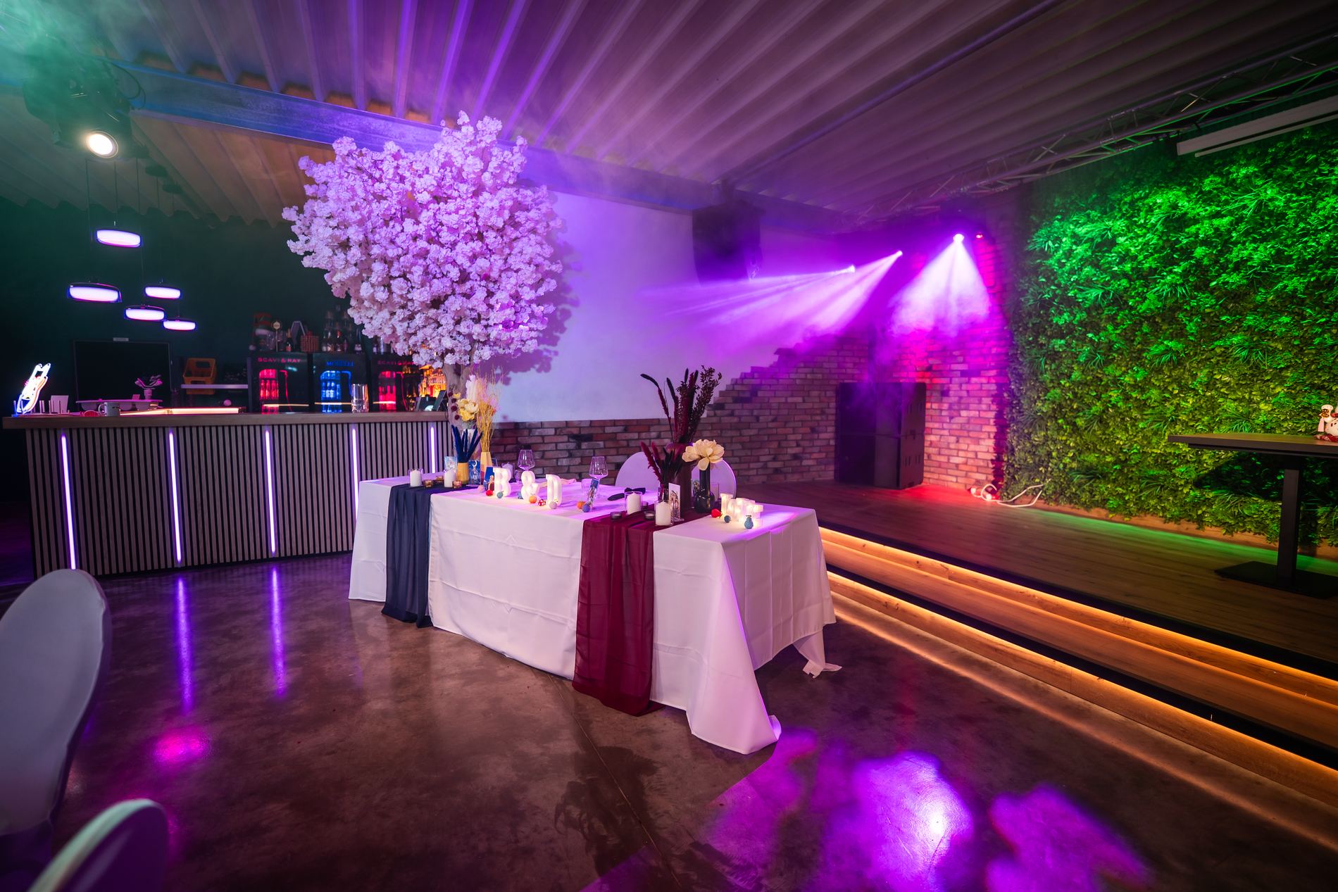 Großer Saal bei Nacht mit Partylicht in Grün und Magenta