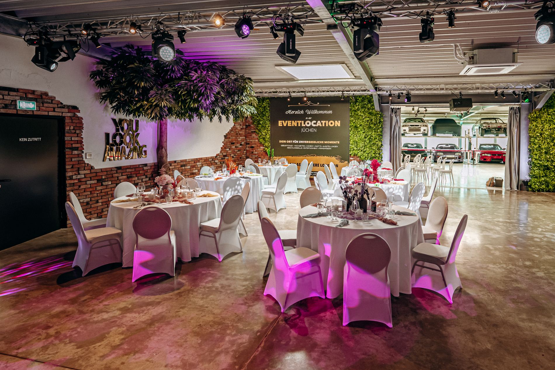 Festlich gedeckte Rundtische im großen Saal am Abend
