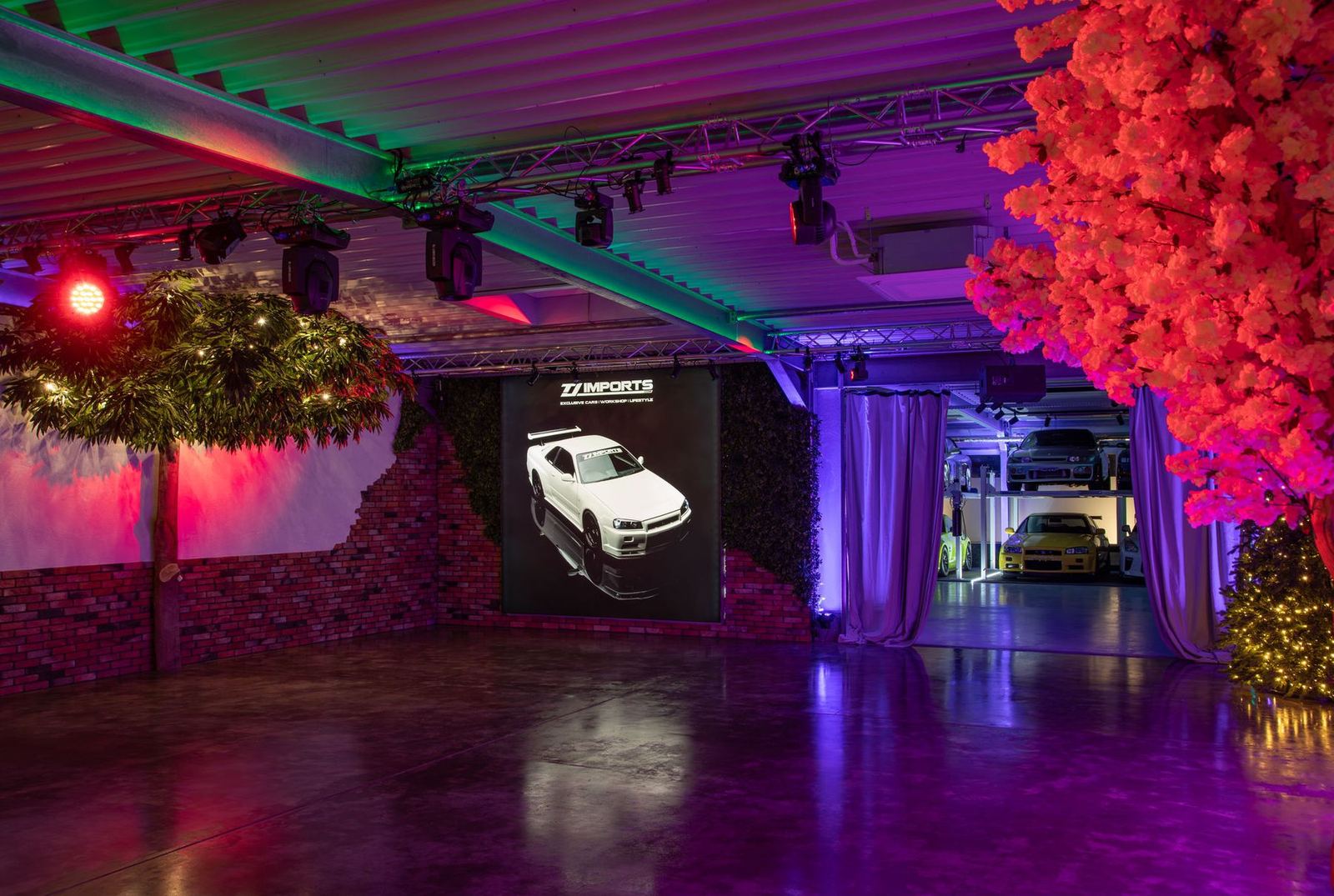 Showroom mit Sportwagen und pinker Eventbeleuchtung bei der Eröffnungsfeier